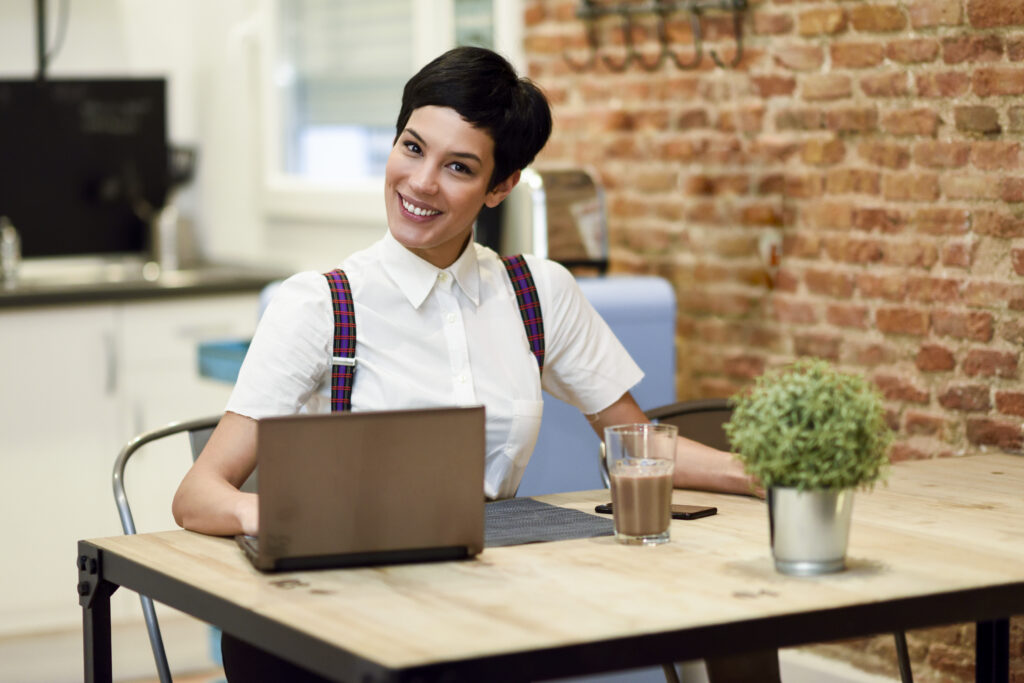 vecteezy young woman with very short haircut typing with a laptop at 184